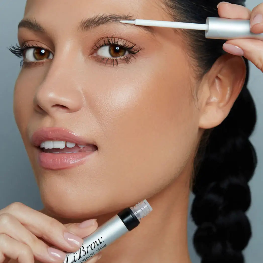 Woman applying eyebrow serum for fuller, defined brows with precision brush applicator