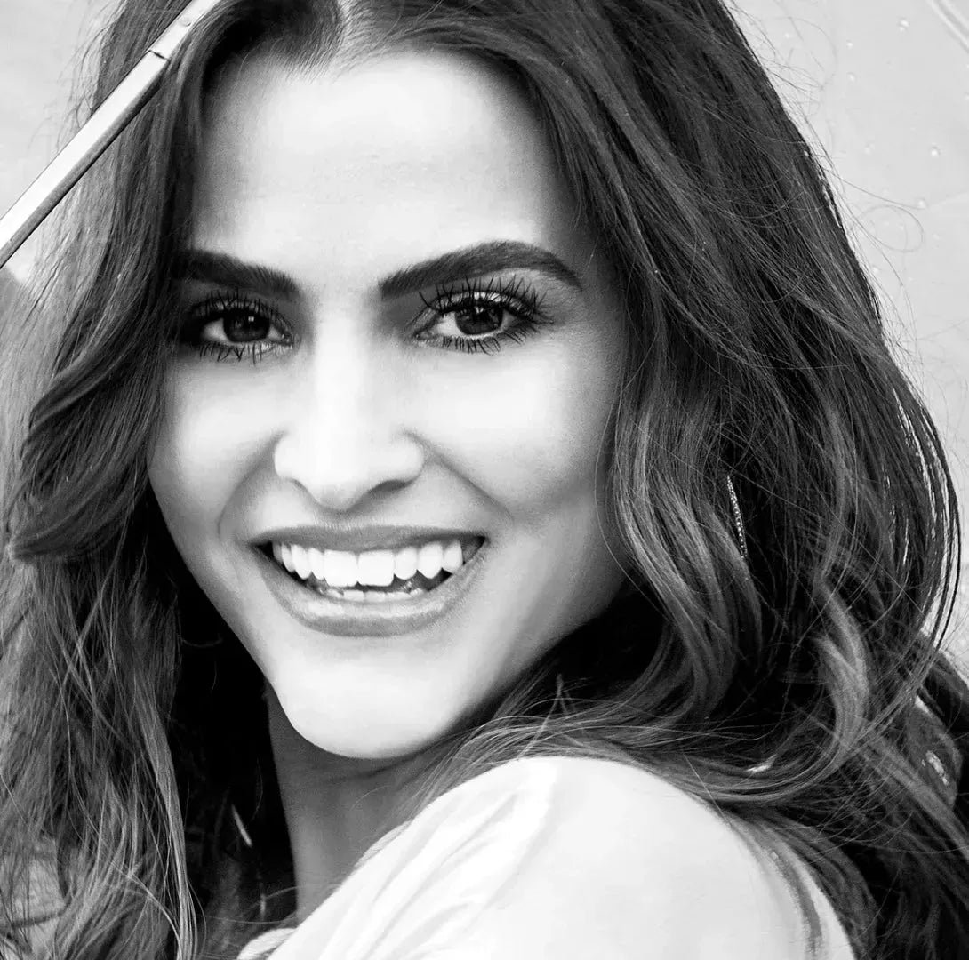 Woman with long, full lashes and defined brows smiling brightly