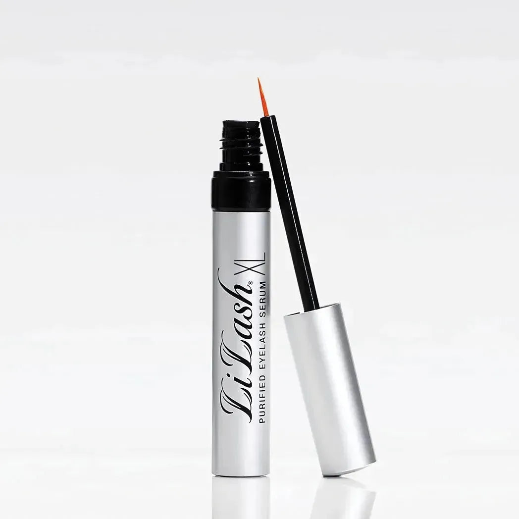Open tube of LiLash XL purified eyelash serum with applicator brush on white background