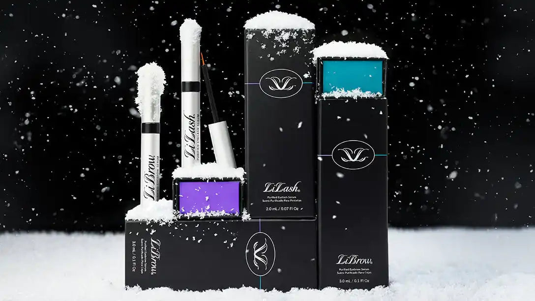 LiLash Beauty eyelash and eyebrow serums in black packaging with snow accents on a black background