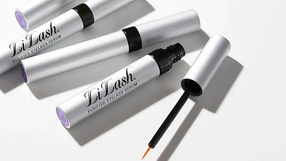 LiLash Purified Eyelash Serum silver tubes with one open applicator brush on white background