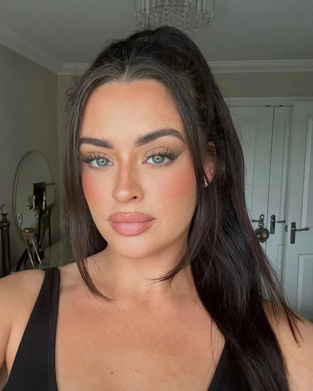 Woman with long, voluminous lashes and defined brows, showcasing natural beauty look