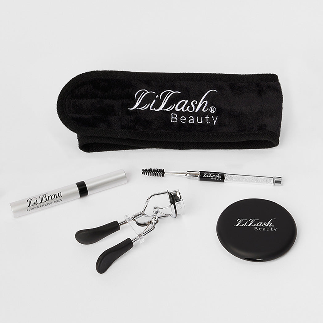 LiLash Beauty set featuring black headband, lash curler, LiBrow serum, spoolie brush, and compact on white background