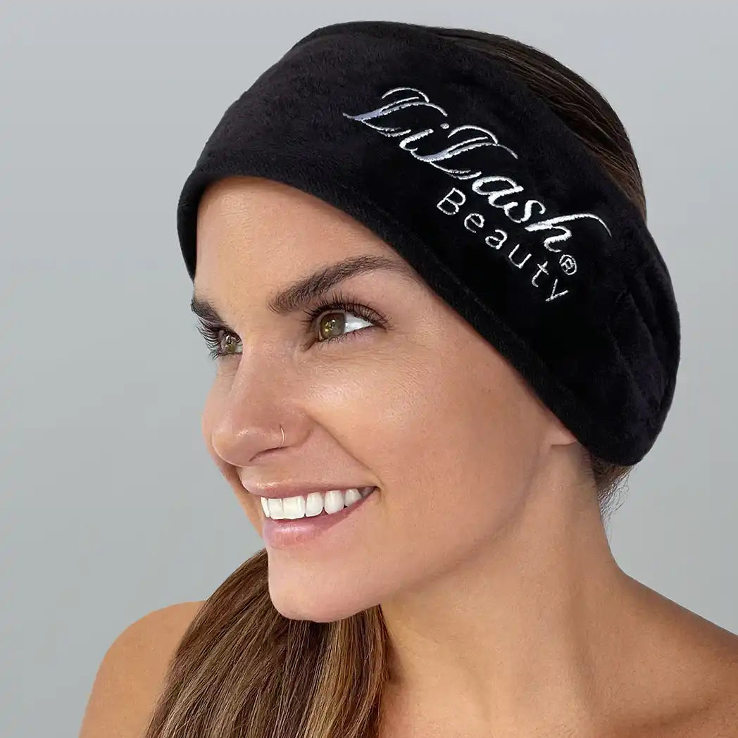 Smiling woman wearing a black Lilash Beauty spa headband, with clear skin and brown hair